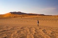 Tourist walking on the sand dunes at Sossusvlei, Namib desert, Namib Naukluft National Park, Namibia. Traveling people, adventure