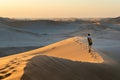 Tourist walking on the scenic dunes of Sossusvlei, Namib desert, Namib Naukluft National Park, Namibia. Afternoon light. Adventure Royalty Free Stock Photo