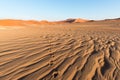 Tourist walking on the scenic dunes of Sossusvlei, Namib desert, Namib Naukluft National Park, Namibia. Afternoon light. Adventure Royalty Free Stock Photo