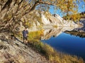 A tourist walking on a shore on the Blue Lake at St Bathans in Otago region of the South Island of New Zealand