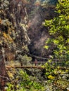 A tourist walking on a suspended bridge in a narrow gorge