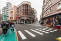 Tourist walks in Yehliu fisherman village downtown area with road, crosswalk and buildings in northern Taipei