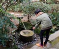 A tourist washing hands at the park in Kyoto, Japan