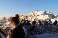 Tourist watching and taking photos of sunset in Oia village. Royalty Free Stock Photo