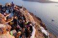 Tourist watching and taking photos of sunset in Oia village. Royalty Free Stock Photo