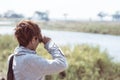 Tourist watching wildlife by binocular on Chobe River, Namibia Botswana border, Africa. Chobe National Park, famous wildlilfe rese Royalty Free Stock Photo