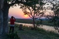 Tourist watching wildlife by binocular on Chobe River at sunrise. Chobe National Park, famous wildlilfe reserve and upscale travel Royalty Free Stock Photo