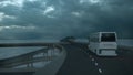 Tourist white bus driving on the bridge under an ominous cloudy sky. 3d Rendering Royalty Free Stock Photo