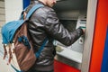 The tourist withdraws money from the ATM for further travel. Grabs a card from the ATM. Finance, credit card, withdrawal