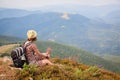 tourist woman with backpack in summer dress with flowers enjoying view. trekking in the mountains