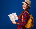 Tourist woman on blue background with map looking into distance Royalty Free Stock Photo