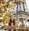Tourist woman on embankment near Eiffel tower in Paris with map Royalty Free Stock Photo