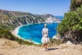 A tourist woman enjoying beautiful Petani beach on Kefalonia Ionian island, Greece, during her summer vacation holiday