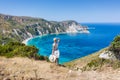 A tourist woman enjoying beautiful Petani beach on Kefalonia Ionian island, Greece, during her summer vacation holiday