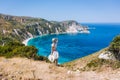 A tourist woman enjoying beautiful Petani beach on Kefalonia Ionian island, Greece, during her summer vacation holiday