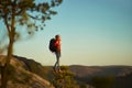 Toutist woman enjoying nature, hiking expedition outdoors on top of mountain at sunset.