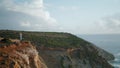 Tourist woman enjoying sea rocky landscape. Tranquil lady relaxing on ocean