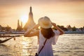 A woman enjoys the view to the famous Wat Arun temple in Bangkok