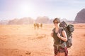 Tourist woman with friends in a desert. Jordan natural park Wadi Rum. Backpacker on the road. Woman hiker with backpack