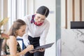 Tourist woman going to fill and sign hotel check in registration form at reception counter, kundenservice when arrival destination Royalty Free Stock Photo