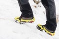 Tourist woman hiking in the snowy mountains. Crampons on shoes.