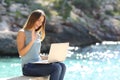 Tourist woman on holidays enjoying online with a laptop