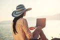 Tourist woman on holidays enjoying online with a laptop on the beach Royalty Free Stock Photo