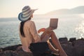 Tourist woman on holidays enjoying online with a laptop on the beach Royalty Free Stock Photo
