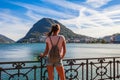 Tourist woman of the lake Lugano, mountains and city Lugano, Ticino canton, Switzerland. Traveler in scenic beautiful Swiss town Royalty Free Stock Photo