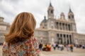 Tourist woman looking at the imposing facade of the Almudena Cathedral in Madrid.