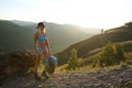 Tourist woman mountain hiker with backpack stands on mountains