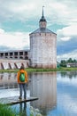 Tourist woman in orange raincoat looking at famous Kirillo-Belozersky monastery near Vologda city. Local travel in Russia North