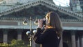 Tourist woman photographing sights. Media. Side view of young female traveler in casual outfit visiting historic Royalty Free Stock Photo