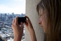 A tourist woman photographs a city with her mobile phone