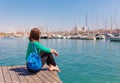 Tourist woman in the port of Barcelona, Catalonia, Spain. Scenic seascape of marina and sailboats yachts. Public promenade and Royalty Free Stock Photo