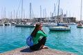 Tourist woman in the port of Barcelona, Catalonia, Spain. Scenic seascape of marina and sailboats yachts. Public promenade and Royalty Free Stock Photo