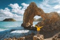 Tourist woman raised hands enjoying rocky arch in the sea view outdoor Travel in Greece