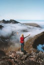 Tourist woman raised hands on mountain top over clouds travel activity summer vacations hike with backpack