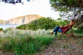 Tourist woman resting sitting on wooden deckchair on the beach in Village Camping Odyssey located in Cilento National park