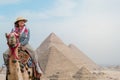 tourist woman riding a dromedary in front of pyramids. Egypt, Cairo - Giza Royalty Free Stock Photo