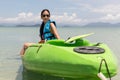 Tourist woman sitting on kayak lookign at beautiful tropical beach on vacation.