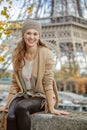 Tourist woman sitting on parapet on embankment near Eiffel tower Royalty Free Stock Photo