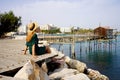 Tourist woman sitting on seafront relaxed with trabucco traditional fishing machine in Termoli village, Molise, Italy