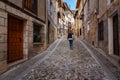 Tourist woman strolling down an alley with cobblestone floor in the medieval town of Frias, Burgos.