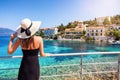 A tourist woman with sunhat looks at the beautiful village of Fiscardo, Kefalonia, Greece Royalty Free Stock Photo