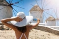 Tourist woman takes a picture of the famous windmills of Mykonos, Royalty Free Stock Photo