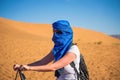 Tourist rides a camel through the sand dunes in the Sahara desert Royalty Free Stock Photo