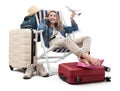 Tourist woman in travel attire, on deck chair with trolley suitcases, show a model airplane, using mobile phone. Summer beach