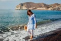 Tourist woman walking on coastline of Red beach Santorini island Greece barefooted. Traveling and summer vacation Royalty Free Stock Photo