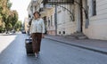 tourist woman walks with a suitcase down the street in a European city, tourism in Europe. Walking the streets. Copy Royalty Free Stock Photo